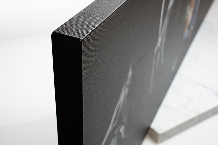Close-up detail of a gallery-wrapped canvas print showing the textured surface and finished edge