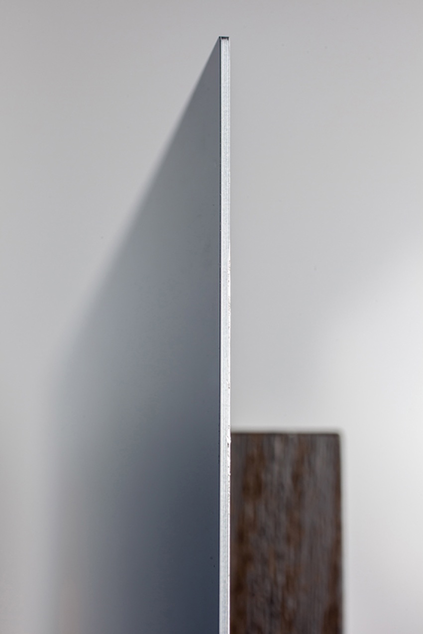 Close-up of a metal print edge showing the slim aluminium profile floating off the wall